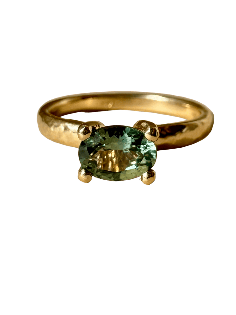 Gold ring with a green gemstone on a transparent background