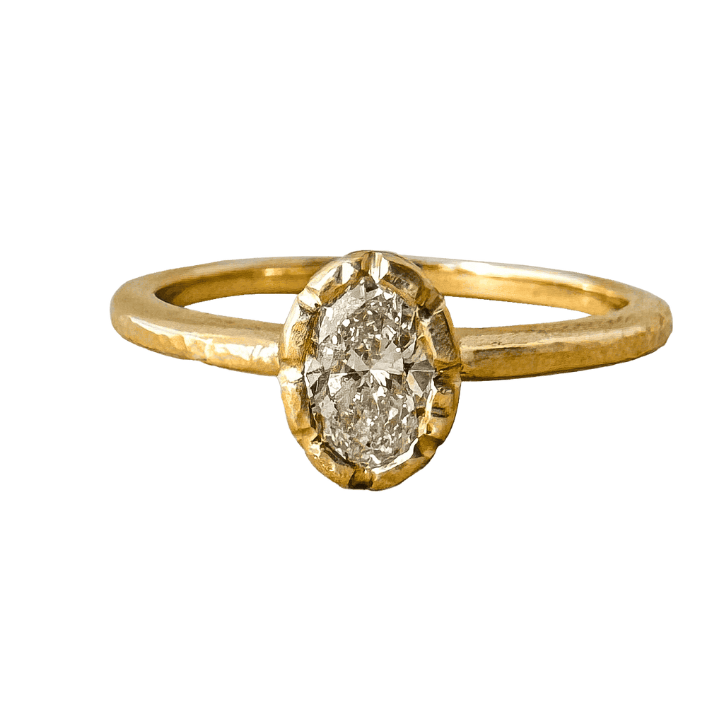 An oval lab diamond set in a unique bezel setting, resembling the petals of a wildflower. The yellow gold ring's design is delicate and nature-inspired.