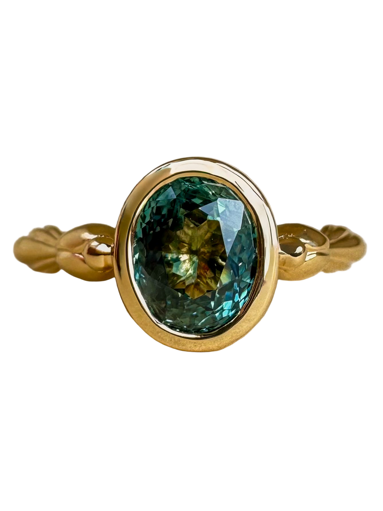Gold ring with a green gemstone on a white background